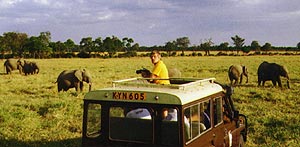 Charles Fracé standing up through the roof of a Land Rover in Africa